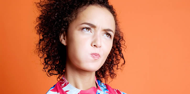 Frau verzieht beim Nachdenken das Gesicht