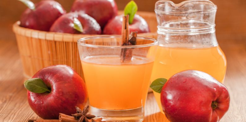 aepfel im korb und apfelsaft in glaesern